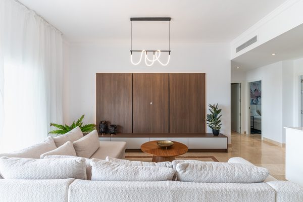 Salon z sofą i drewnianą zabudową ścienną