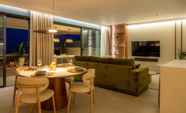 Jadalnia i salon wieczorem: okrągły stół, zielona sofa, ciepłe światło