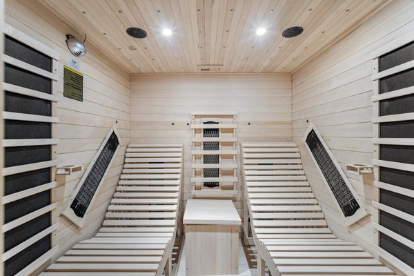 Sauna wyłożona jasnym drewnem z promiennikami podczerwieni