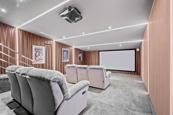 Prywatna sala kinowa z ekranem projekcyjnym i fotelami relaksacyjnymi