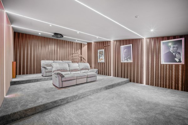 Sala kinowa od strony wejścia — tapicerowane ściany i sofa
