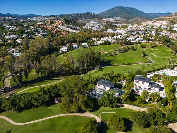 Panorama Nueva Andalucía z lotu ptaka: pola golfowe, wille i góry na horyzoncie